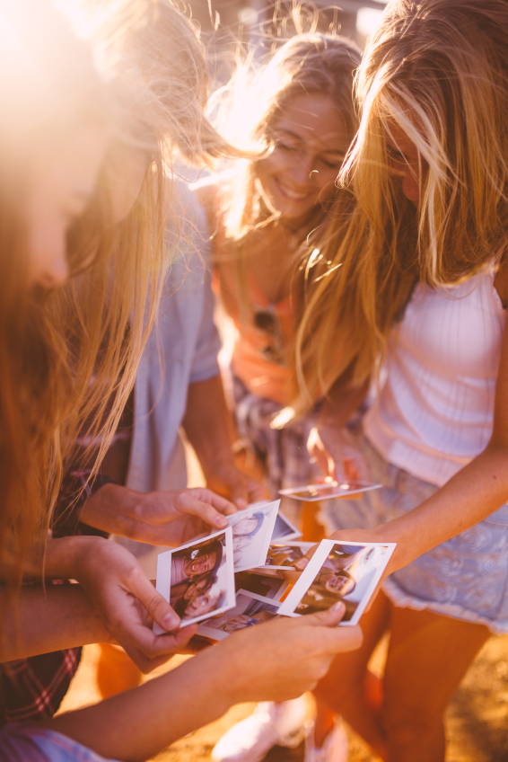 Group of teens sharing instant photographs
