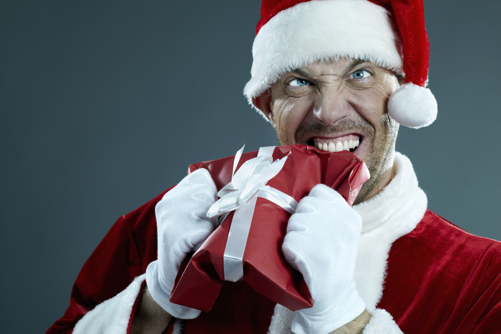 Aggressive Santa Claus biting a gift box